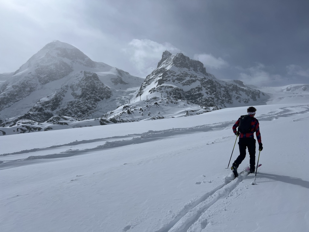 Ski mountaineer skinning toward alpine peaks