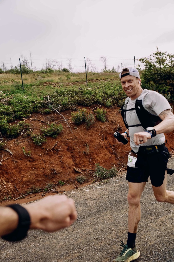 Coach Elliott Bates fist bumping after a mountain endurance effort