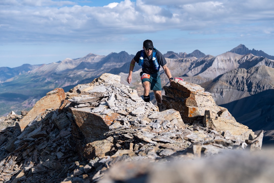 Runner on rocky ridge with panoramic mountain views